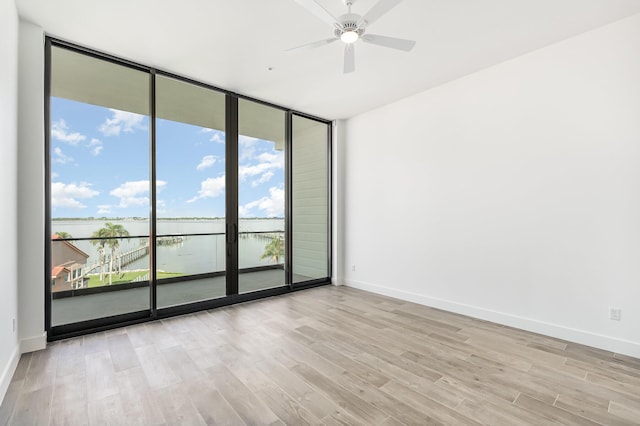 unfurnished room featuring a water view, ceiling fan, and light hardwood / wood-style floors