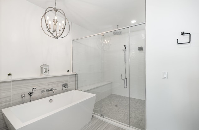 bathroom featuring shower with separate bathtub and a chandelier