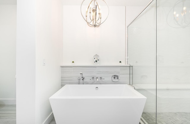 bathroom featuring a bath and a notable chandelier