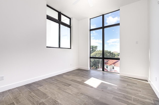 unfurnished room featuring ceiling fan and expansive windows