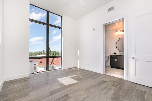 spare room featuring expansive windows and ceiling fan