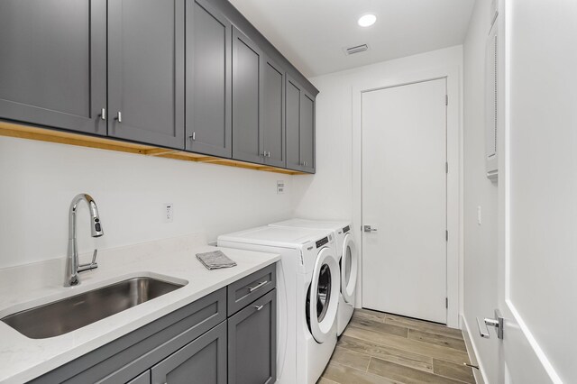 laundry room with cabinets, sink, and washing machine and clothes dryer