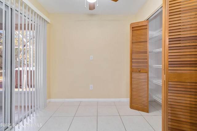 interior space with light tile patterned floors and ceiling fan