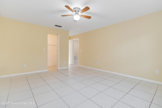 tiled spare room featuring ceiling fan