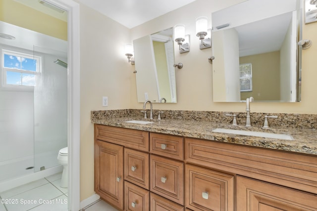 bathroom featuring tile patterned floors, vanity, a shower with shower door, and toilet