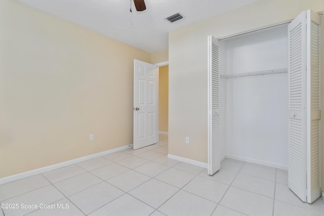 unfurnished bedroom featuring ceiling fan, light tile patterned floors, and a closet