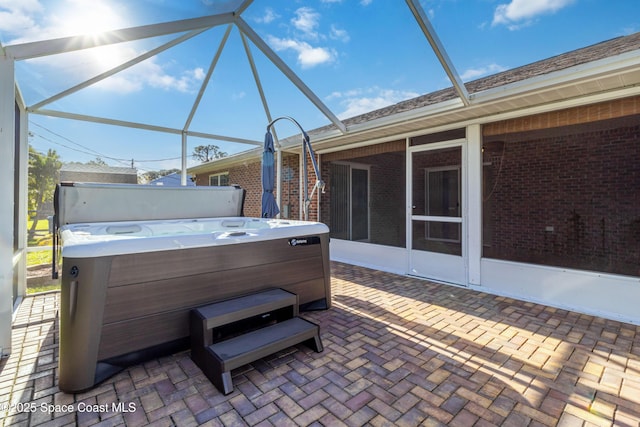 view of patio / terrace with a hot tub, a lanai, and a sunroom