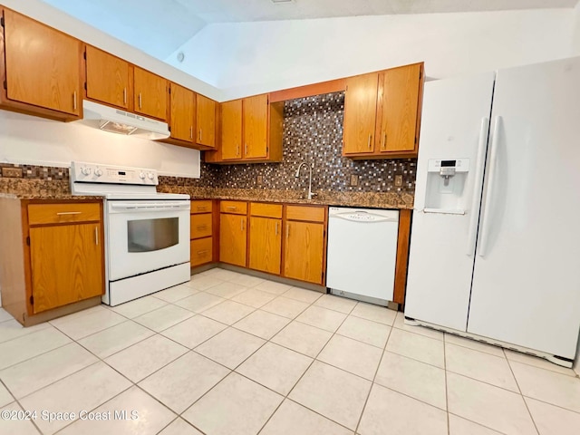 kitchen featuring light tile patterned floors, white appliances, vaulted ceiling, and sink