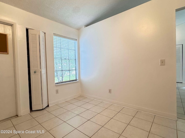 unfurnished bedroom with light tile patterned floors and a textured ceiling