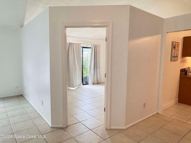 hallway with light tile patterned floors and a textured ceiling