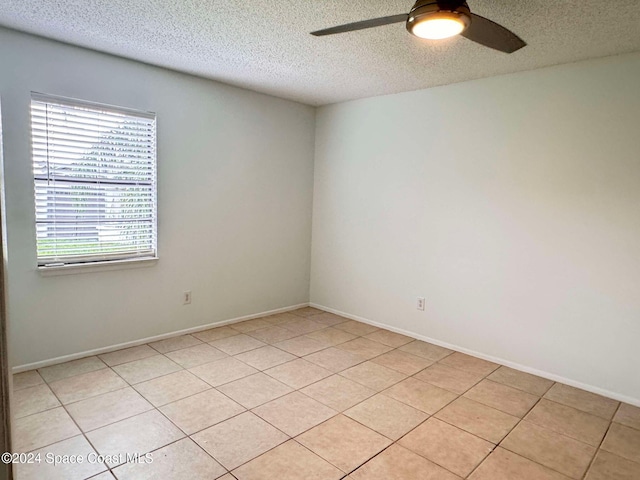 tiled empty room with a textured ceiling and ceiling fan