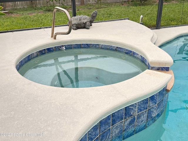 view of swimming pool with an in ground hot tub