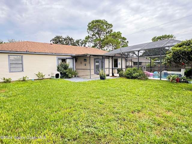 rear view of house featuring glass enclosure and a yard