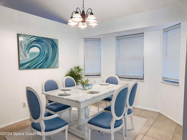 tiled dining room with a notable chandelier