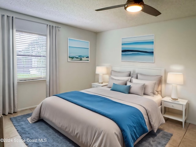 bedroom featuring light tile patterned floors, a textured ceiling, and ceiling fan