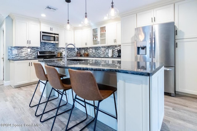 kitchen featuring a kitchen island with sink, sink, white cabinets, and appliances with stainless steel finishes