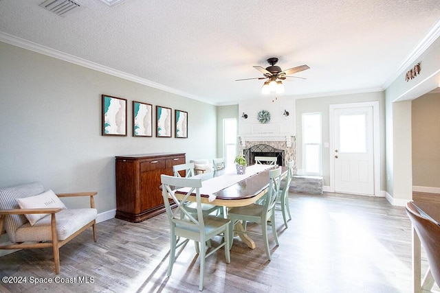 dining space featuring a textured ceiling, light hardwood / wood-style floors, ceiling fan, and ornamental molding