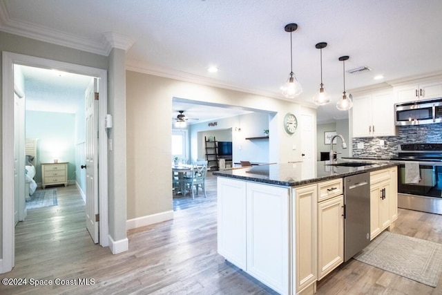 kitchen with a center island with sink, sink, ceiling fan, appliances with stainless steel finishes, and white cabinetry