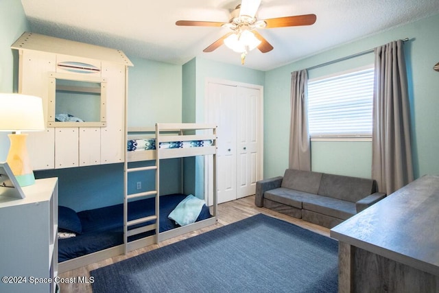 bedroom with a closet, light hardwood / wood-style floors, and ceiling fan