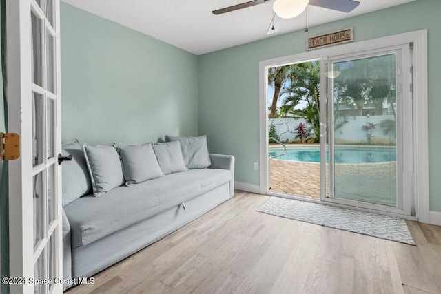 unfurnished living room with ceiling fan, light wood-type flooring, and french doors