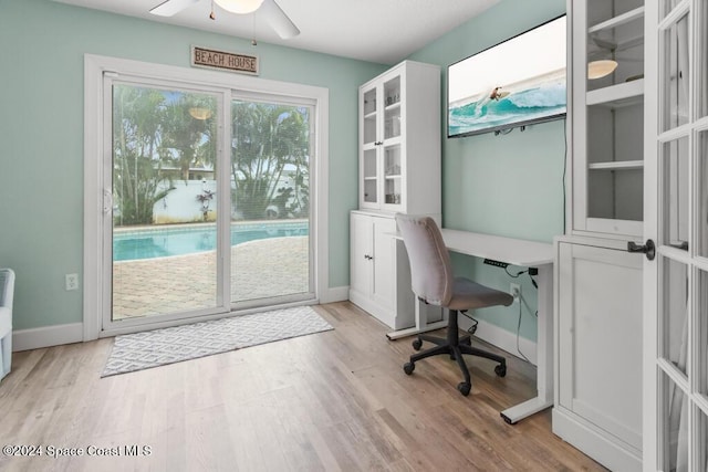 office with ceiling fan, french doors, and light wood-type flooring