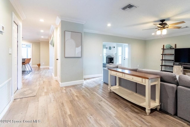 living room featuring light hardwood / wood-style floors, ceiling fan, and ornamental molding