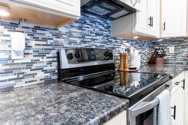 kitchen featuring decorative backsplash, white cabinets, and stainless steel range with electric stovetop