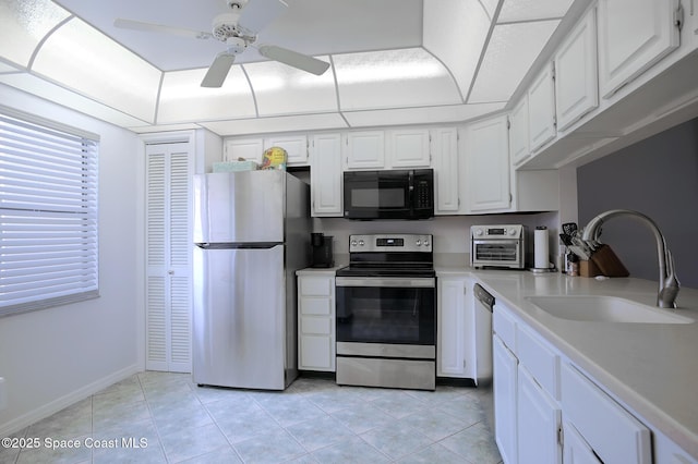 kitchen with stainless steel appliances, white cabinetry, and sink