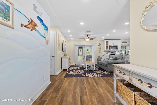 living room featuring ceiling fan and dark wood-type flooring