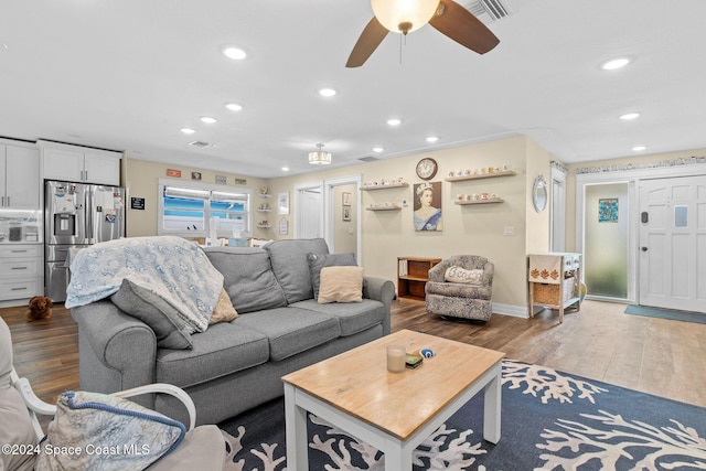 living room featuring ceiling fan and dark wood-type flooring