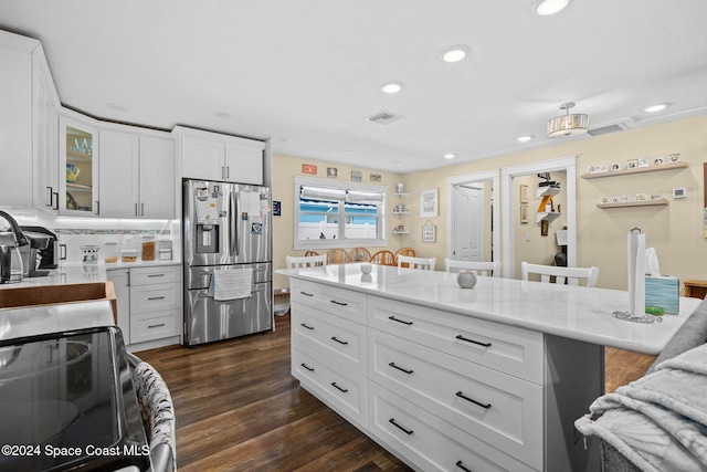 kitchen with white cabinetry, light stone countertops, a kitchen breakfast bar, dark hardwood / wood-style flooring, and stainless steel fridge