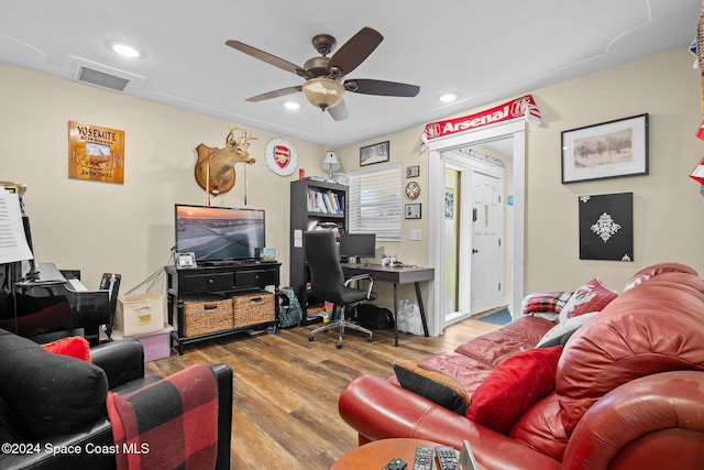 living room featuring hardwood / wood-style floors and ceiling fan