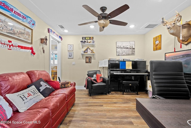 living room featuring ceiling fan and hardwood / wood-style flooring