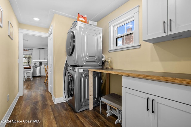 washroom with dark hardwood / wood-style floors, cabinets, and stacked washer / dryer