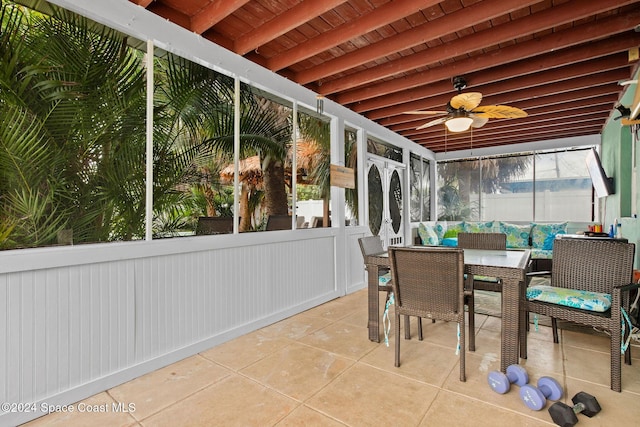 sunroom featuring beam ceiling, ceiling fan, and wood ceiling