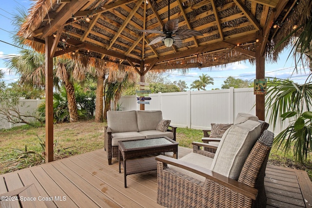 wooden terrace featuring a gazebo and an outdoor living space