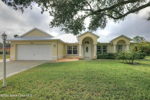 single story home featuring a garage and a front lawn