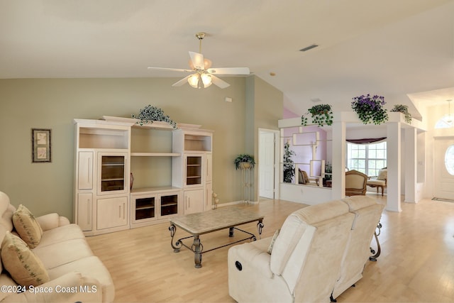 living room featuring ceiling fan, light hardwood / wood-style floors, and vaulted ceiling