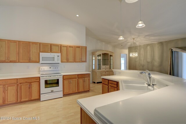 kitchen with white appliances, sink, pendant lighting, high vaulted ceiling, and an inviting chandelier