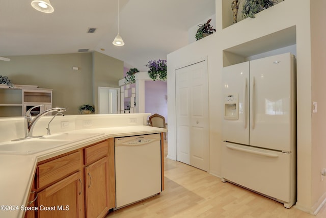 kitchen featuring light wood-type flooring, white appliances, sink, decorative light fixtures, and lofted ceiling