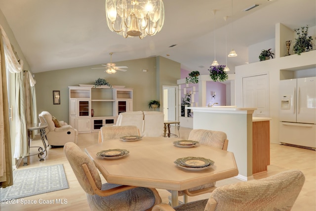 dining room with ceiling fan with notable chandelier and high vaulted ceiling