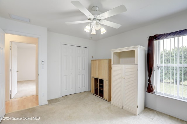 unfurnished bedroom featuring ceiling fan and light carpet