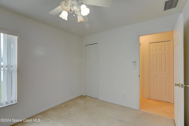 empty room featuring light carpet and ceiling fan