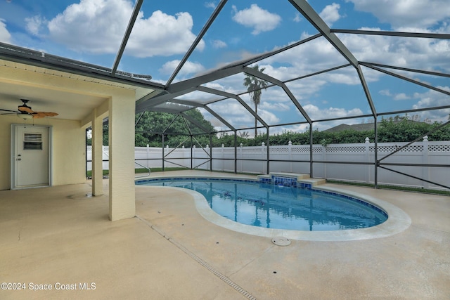 view of swimming pool featuring a patio, glass enclosure, and ceiling fan