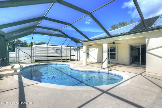 view of pool with a storage unit, glass enclosure, ceiling fan, and a patio area