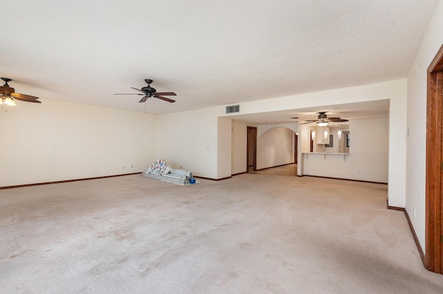 spare room featuring light carpet and a textured ceiling