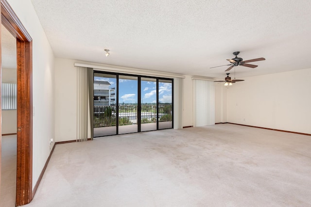 carpeted empty room featuring a textured ceiling and ceiling fan