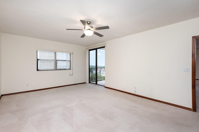 spare room with ceiling fan, light colored carpet, and a textured ceiling