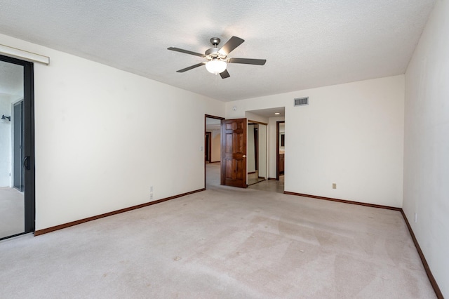 unfurnished bedroom with ceiling fan, light carpet, and a textured ceiling