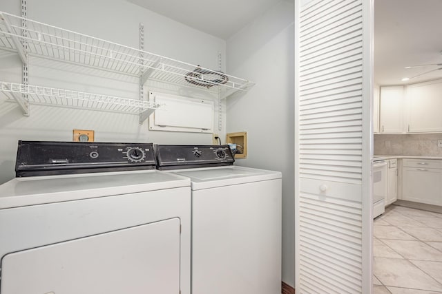 clothes washing area featuring independent washer and dryer, light tile patterned floors, and ceiling fan